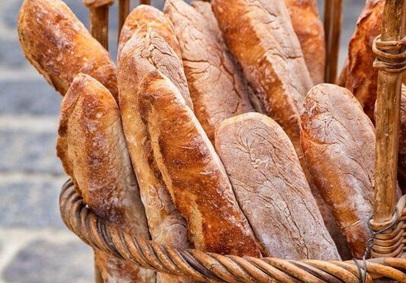 A boulangerie basket filled with golden, crusty French baguettes