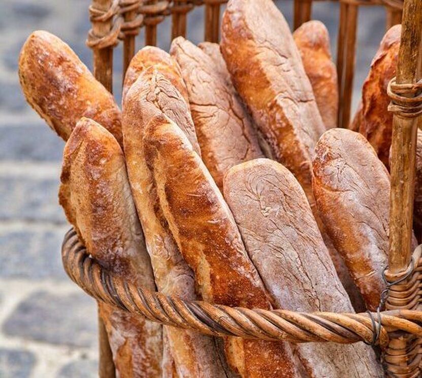 A boulangerie basket filled with golden, crusty French baguettes