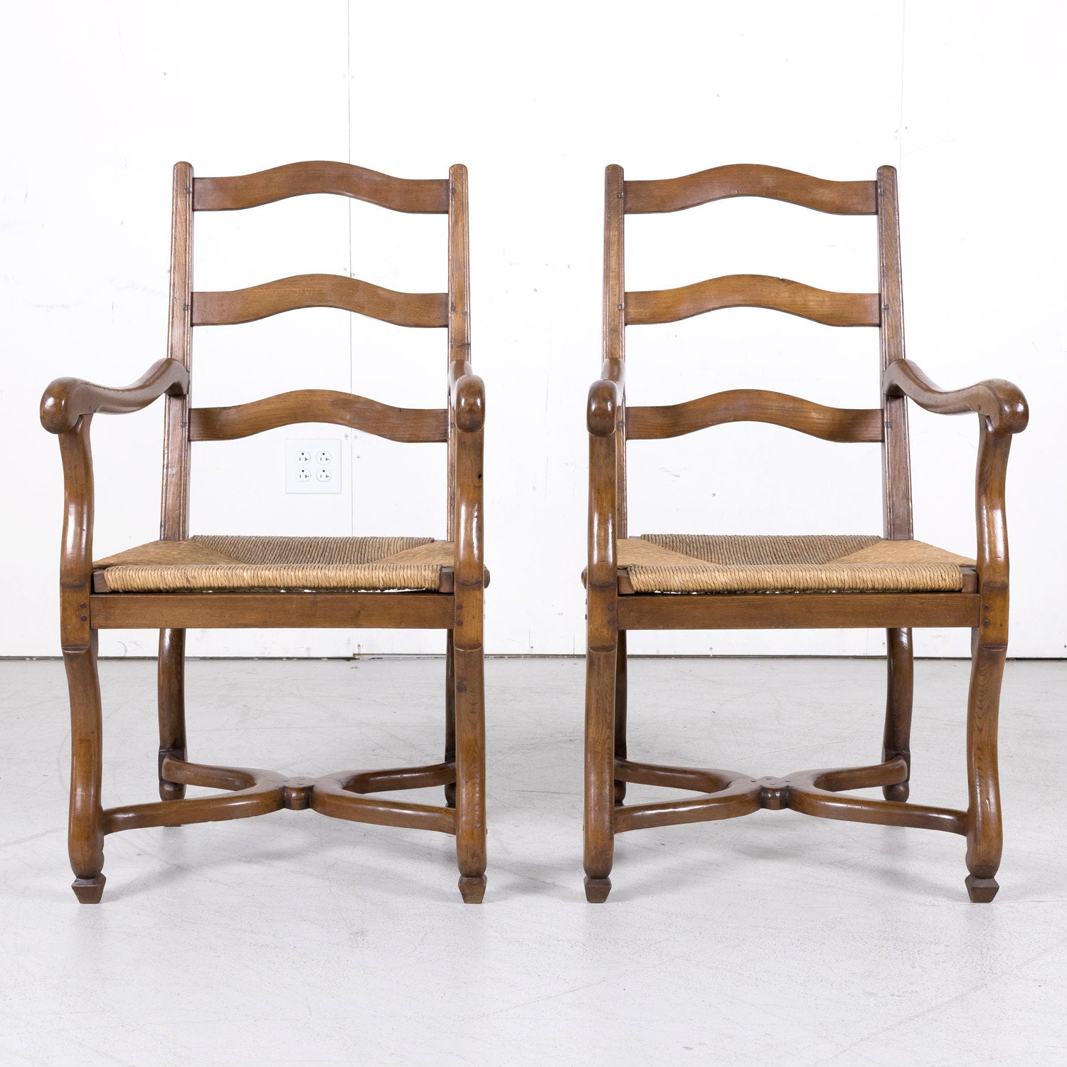 Pair of Antique Country French Louis XIV Style Oak Ladder Back Arm Chairs with Rush Seats