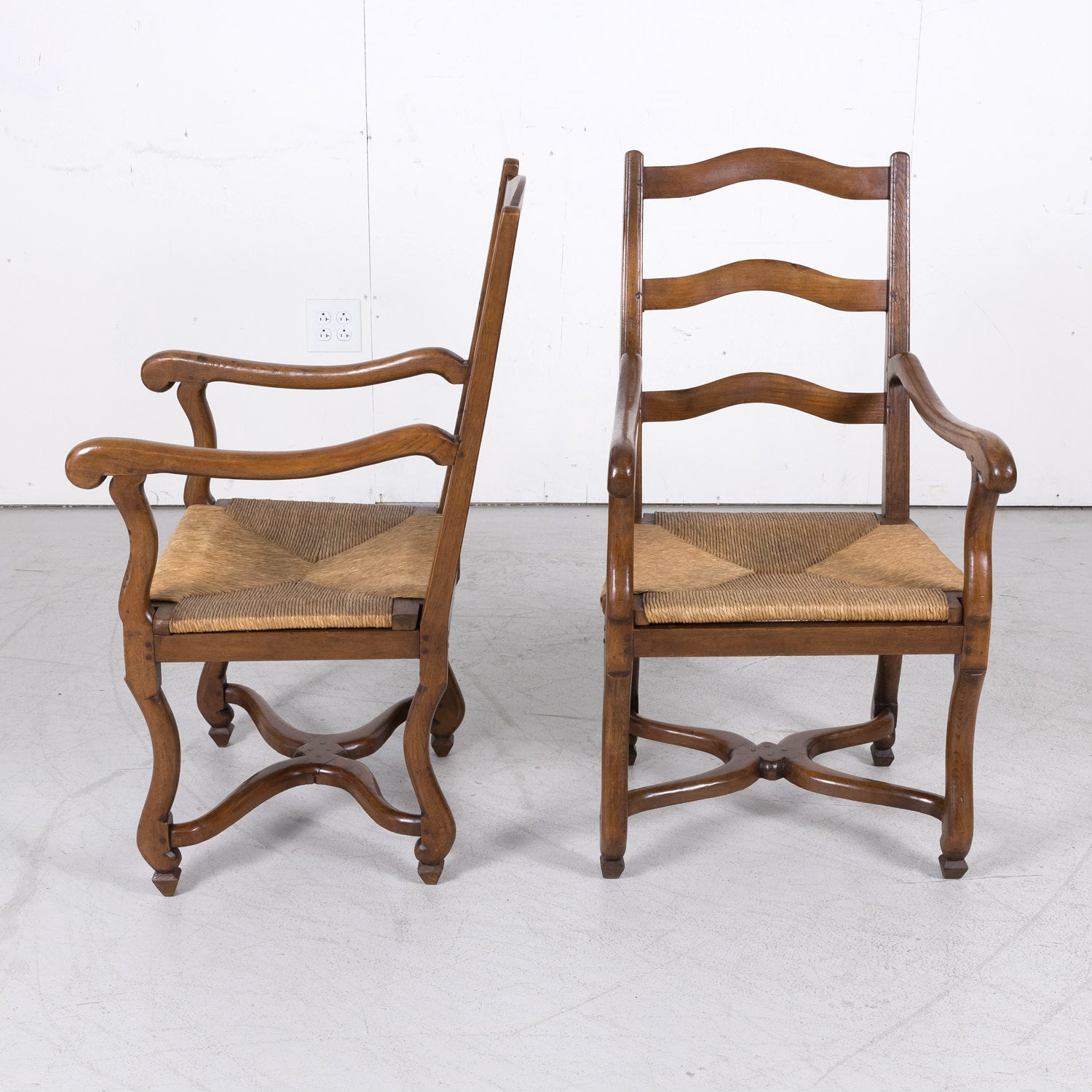 Pair of Antique Country French Louis XIV Style Oak Ladder Back Arm Chairs with Rush Seats