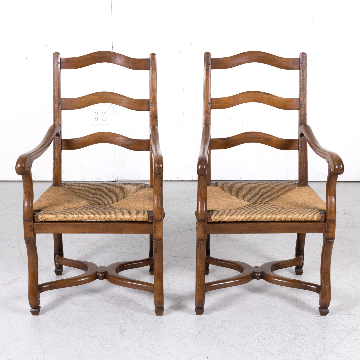 Pair of Antique Country French Louis XIV Style Oak Ladder Back Arm Chairs with Rush Seats