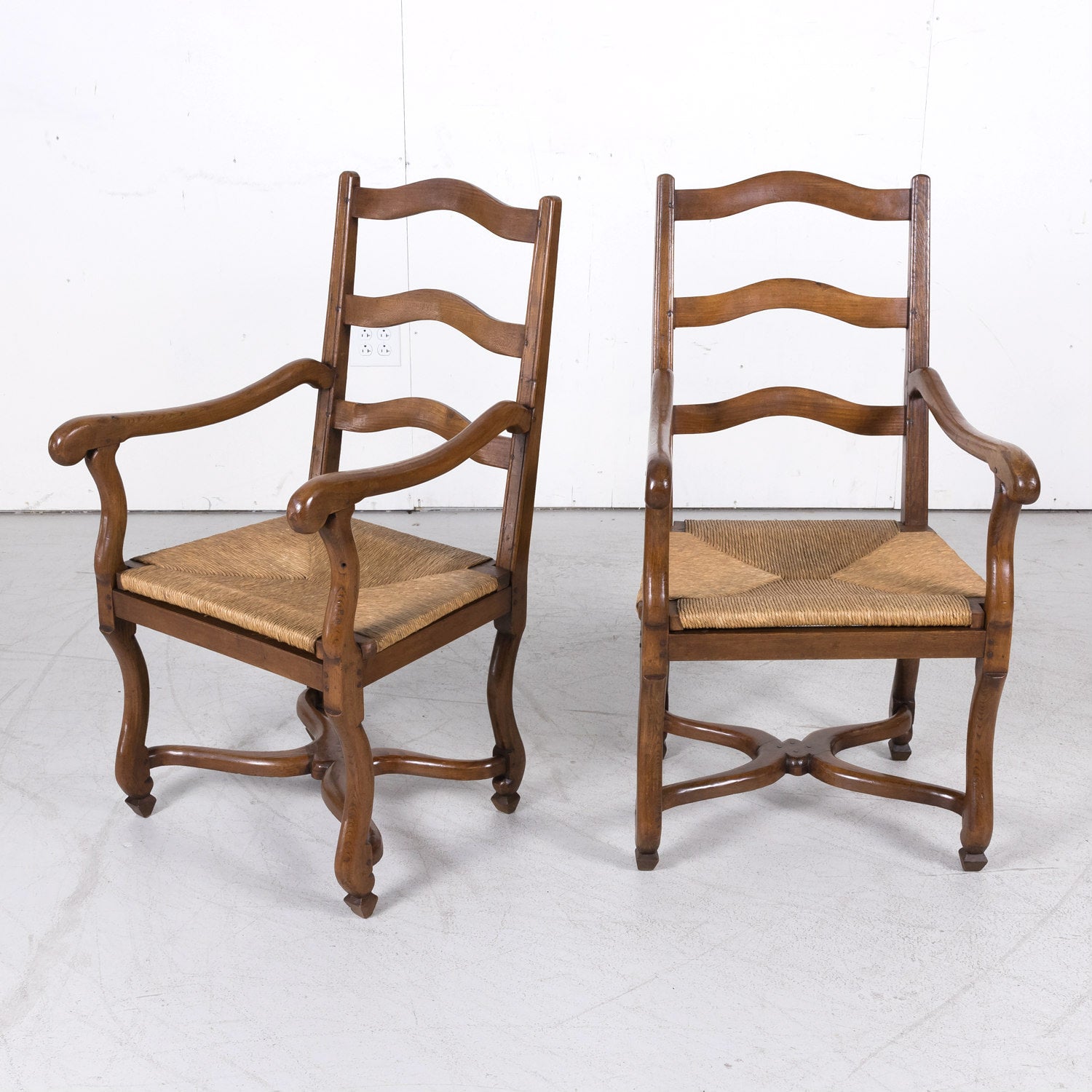 Pair of Antique Country French Louis XIV Style Oak Ladder Back Arm Chairs with Rush Seats