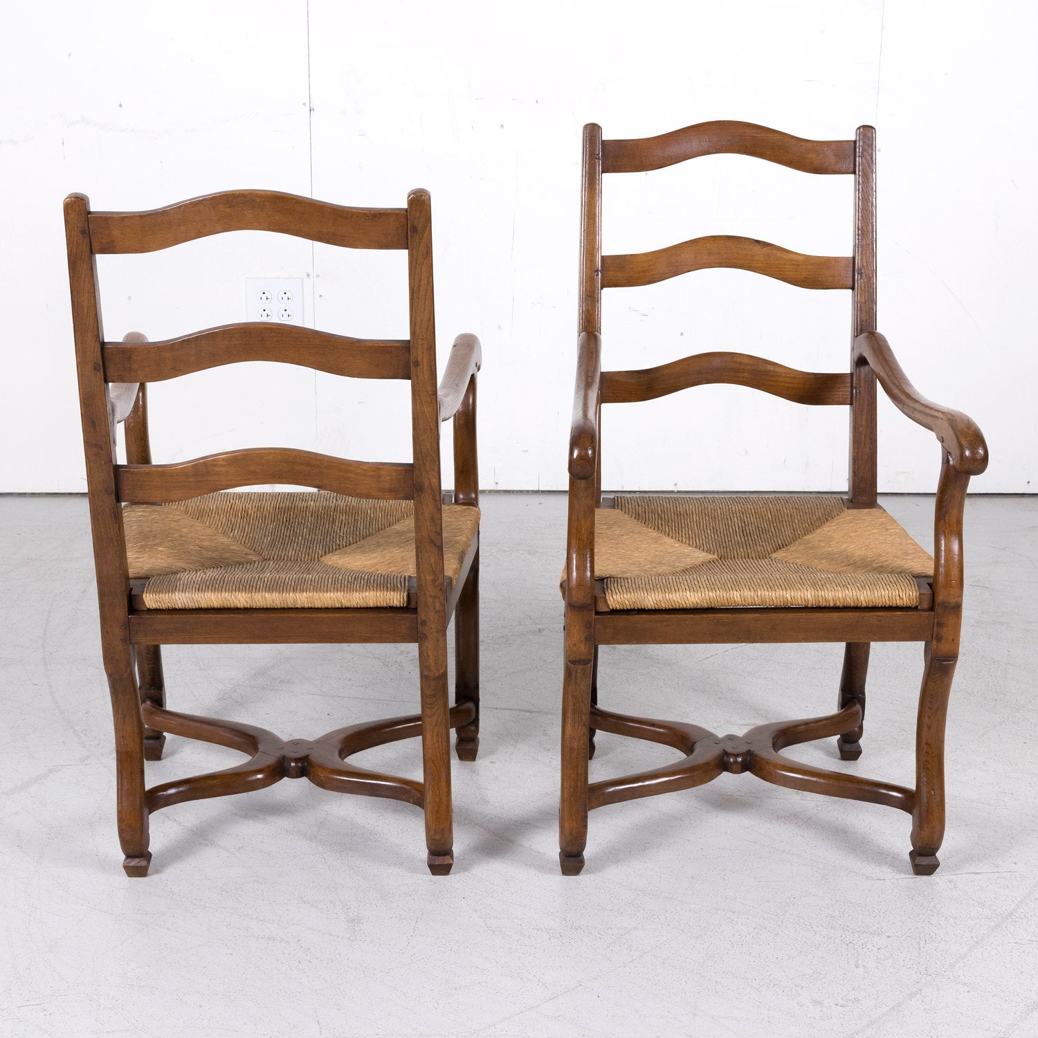 Pair of Antique Country French Louis XIV Style Oak Ladder Back Arm Chairs with Rush Seats
