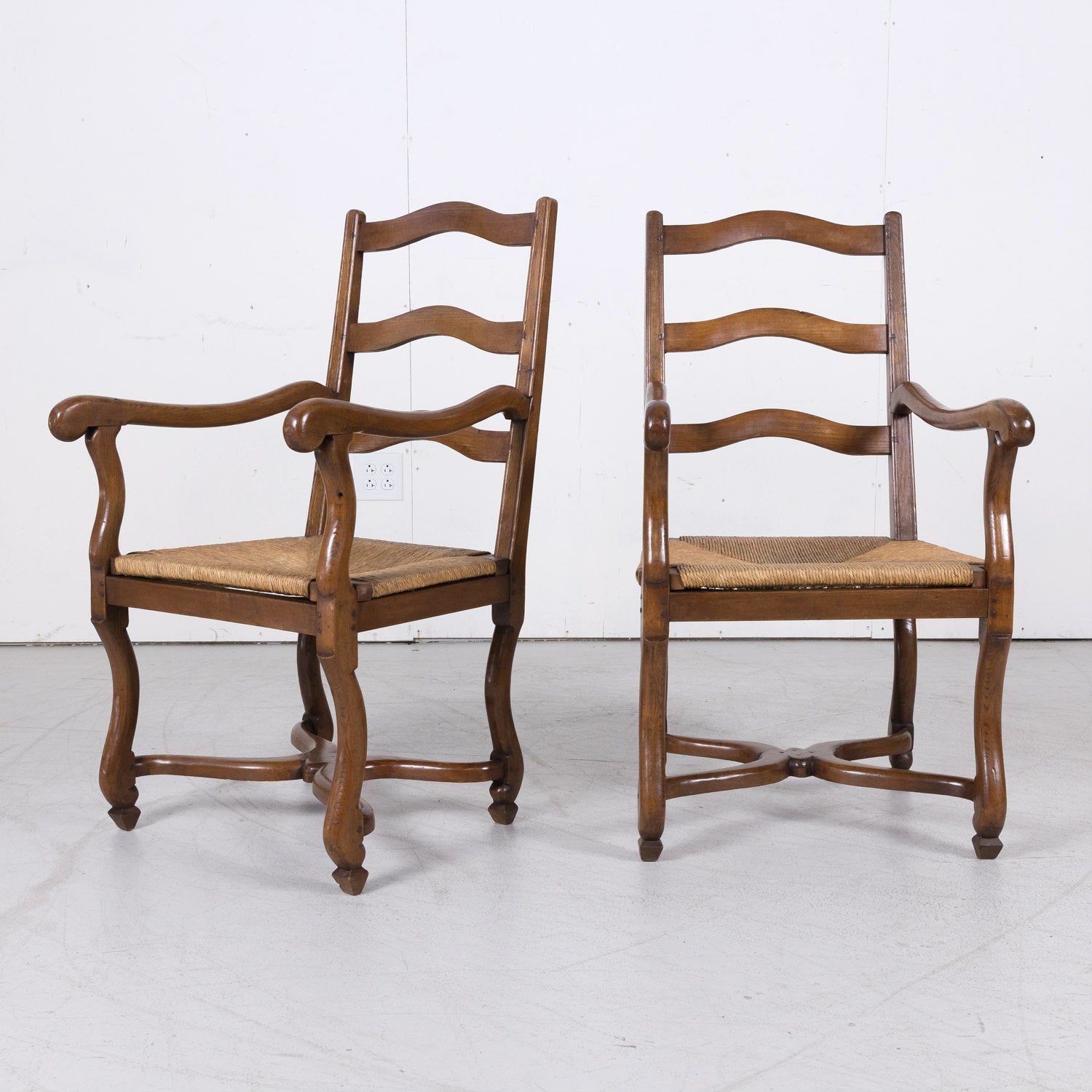 Pair of Antique Country French Louis XIV Style Oak Ladder Back Arm Chairs with Rush Seats
